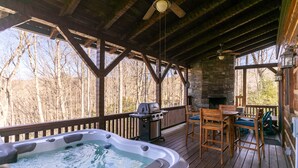 A wooden deck with a hot tub, barbecue grill, and outdoor seating area. - Walk in the Clouds - Rustic Cabin with Hot Tub, Outdoor fireplace, Fenced Dog Area (Boone)