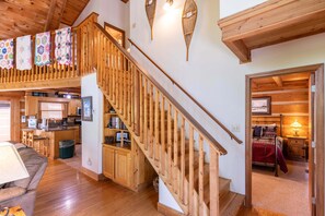 A wooden staircase leading to a loft area with a kitchen and a cozy sitting area. - Almost Heaven: Pet-Friendly Cabin with Yard and Hot Tub in Valle Crucis - Walk to River (Sugar Grove)