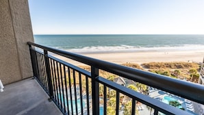 Ein Balkon mit Blick auf Strand und Schwimmbad.