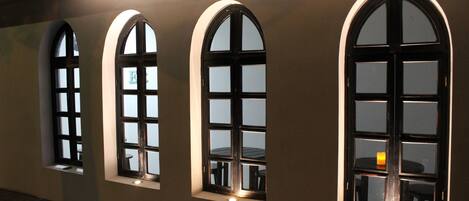 Un pasillo con ventanas de arco y suelo de baldosas.