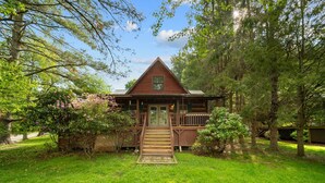 Une cabane en bois dotée d’un porche à l’avant et d’un escalier menant à l’entrée.