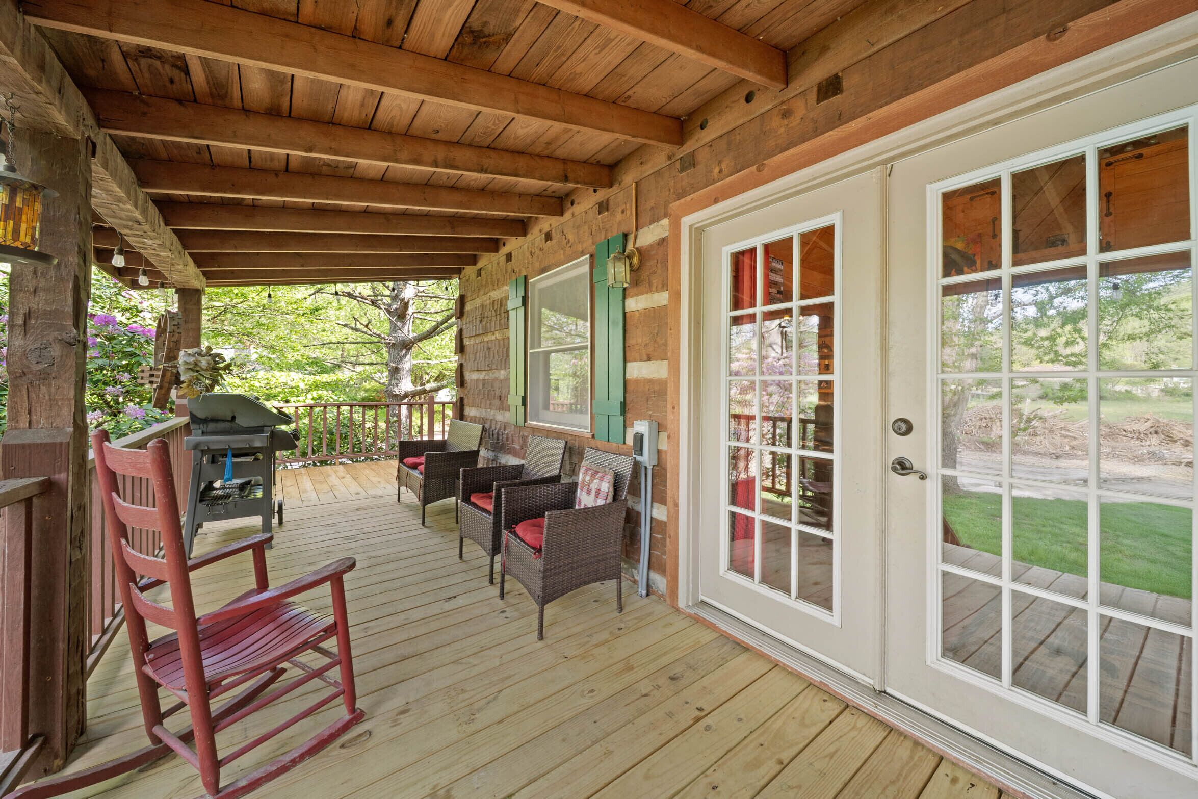 Rock away the afternoon on the covered porch at Bridgepoint Cabin, surrounded by lush spring greenery in Valle Crucis.