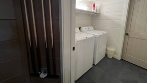 A laundry room with two washing machines, a shelf with items, and a door. - Highland Mist  Pet Friendly, Beautiful Views, Hot Tub, Game Tables, Winery Close by (Banner Elk)