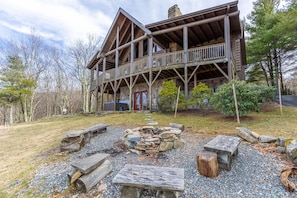 A rustic cabin with a stone fireplace, wooden deck, and a stone pathway leading to the entrance. - Highland Mist  Pet Friendly, Beautiful Views, Hot Tub, Game Tables, Winery Close by (Banner Elk)