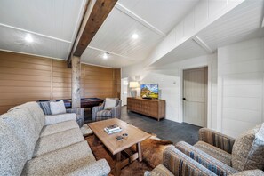 A spacious living room with a pool table, comfortable seating, a coffee table, and a television. - Highland Mist  Pet Friendly, Beautiful Views, Hot Tub, Game Tables, Winery Close by (Banner Elk)