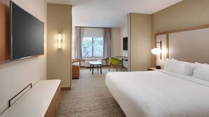 A hotel room with a large bed, a desk, a chair, a flat-screen TV, and a window with curtains. - Fairfield by Marriott Inn & Suites Denver West/Federal Center (Lakewood)