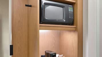 A compact kitchenette with a microwave, coffee maker, and a small refrigerator.