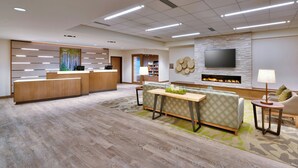A modern hotel lobby with a reception desk, seating area, and a fireplace. - Fairfield by Marriott Inn & Suites Denver West/Federal Center (Lakewood)