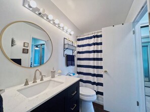 Bañera con ducha, secador de pelo, toallas, papel higiénico
