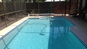 A rectangular swimming pool with a diving board and a fence. - 3 bedroom house w/private heated salt water pool, bbq, quiet location  (Pembroke Pines)