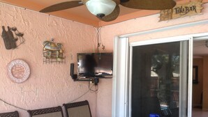 A dining area with a table, chairs, a television mounted on the wall, and a ceiling fan. - 3 bedroom house w/private heated salt water pool, bbq, quiet location  (Pembroke Pines)