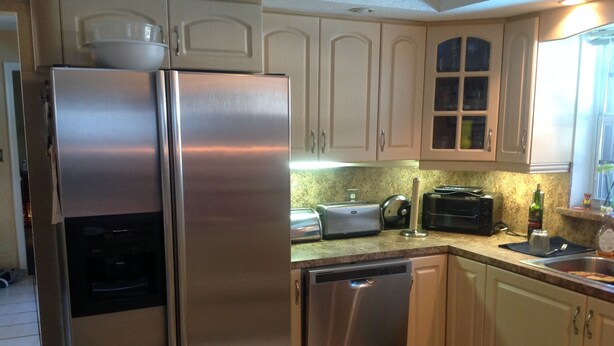 A kitchen with a stainless steel refrigerator, a dishwasher, a toaster, and a sink. - 3 bedroom house w/private heated salt water pool, bbq, quiet location  (Pembroke Pines)