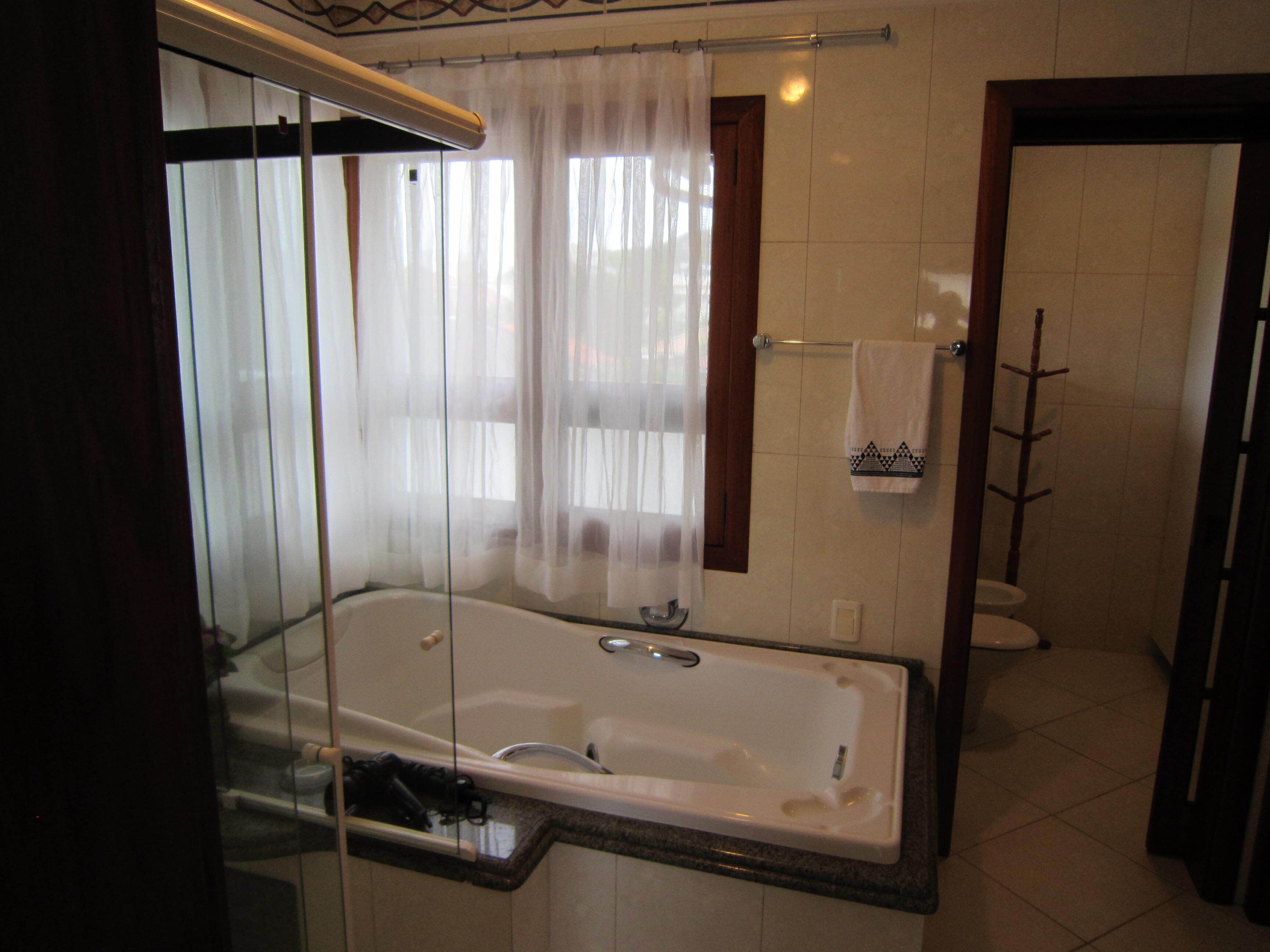 Ein Badezimmer mit einer Glaskonsole Badewanne, einer Duschkabine und einer Toilette.