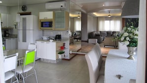 Een moderne keuken met een magnetron, koelkast en een eethoek met stoelen en een tafel.