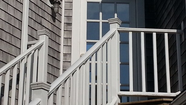 A corner of a building with a white door and a white railing. - Chatham Village - Center - Main Street Center Area (Chatham)