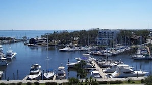 A marina with various boats docked, surrounded by buildings and greenery. - NEW COMPLETE REMODEL, MELBOURNE HARBOUR VIEWS (Melbourne)