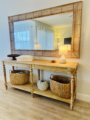 A wooden console table with woven baskets and a large mirror. - NEW COMPLETE REMODEL, MELBOURNE HARBOUR VIEWS (Melbourne)
