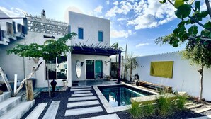 Una casa moderna con piscina, escalera y zona de patio.