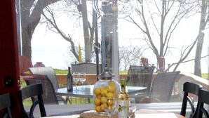 Une table avec un bocal en verre rempli de citrons, une bouteille de vin et deux verres.
