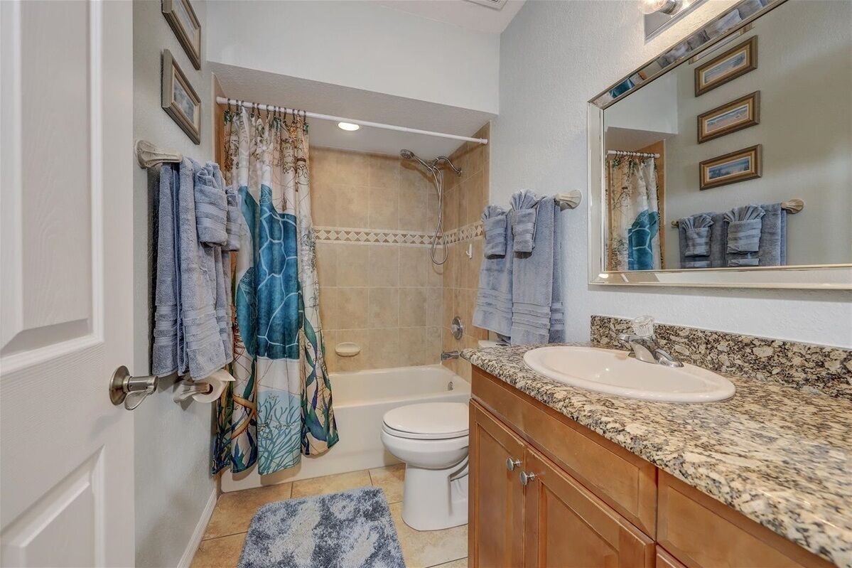 A bathroom with a bathtub, toilet, and sink.