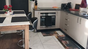 Une cuisine compacte comprenant un coin repas, un petit four et un évier.