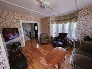 Relax in this inviting living room with a flat-screen TV, comfortable armchair, and plush sofa.