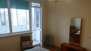Une chambre à coucher avec un lit, une chaise, un miroir et un radiateur.