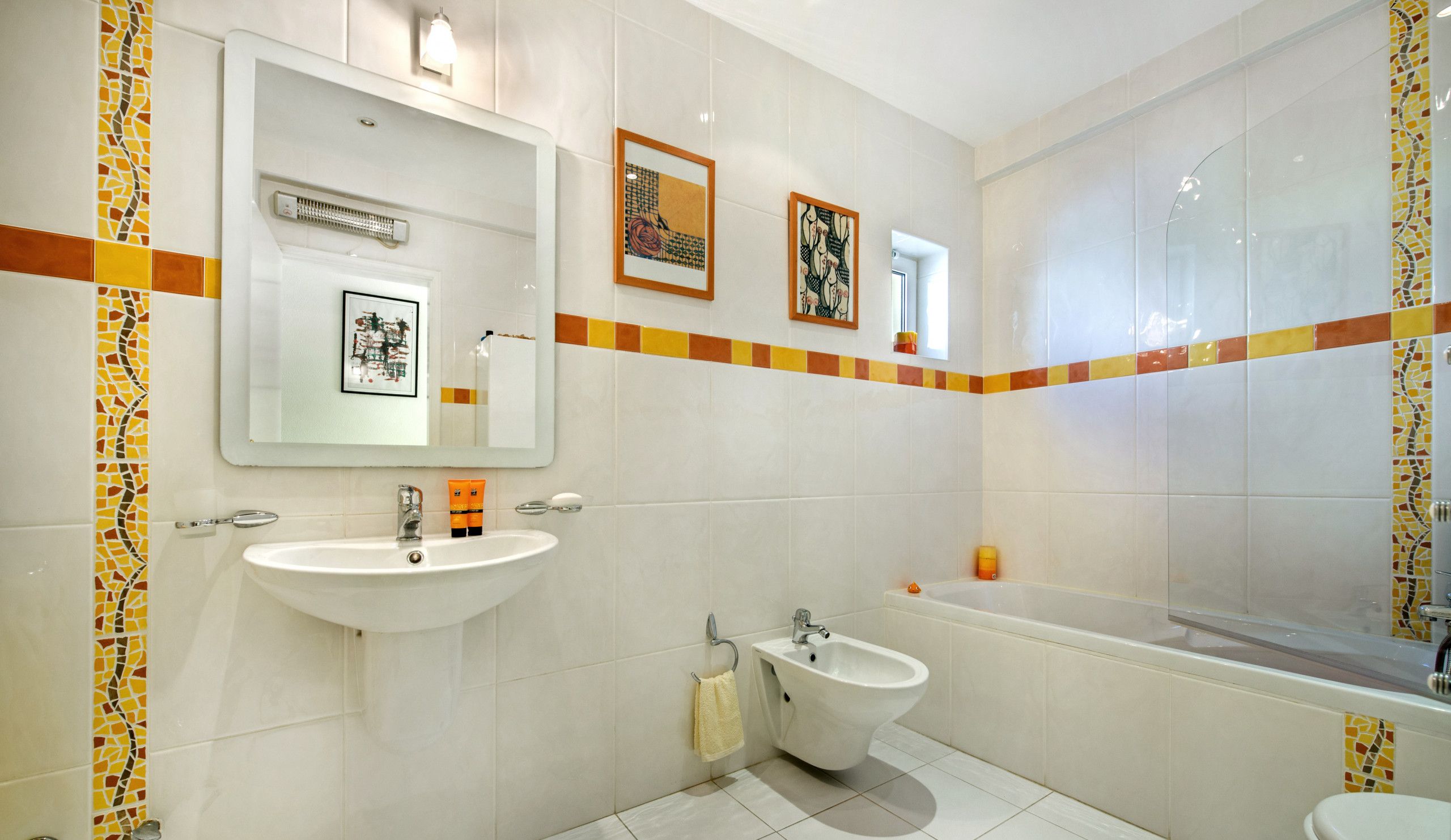 Een badkamer met twee wastafels, een bidet, een badkuip en een douche.