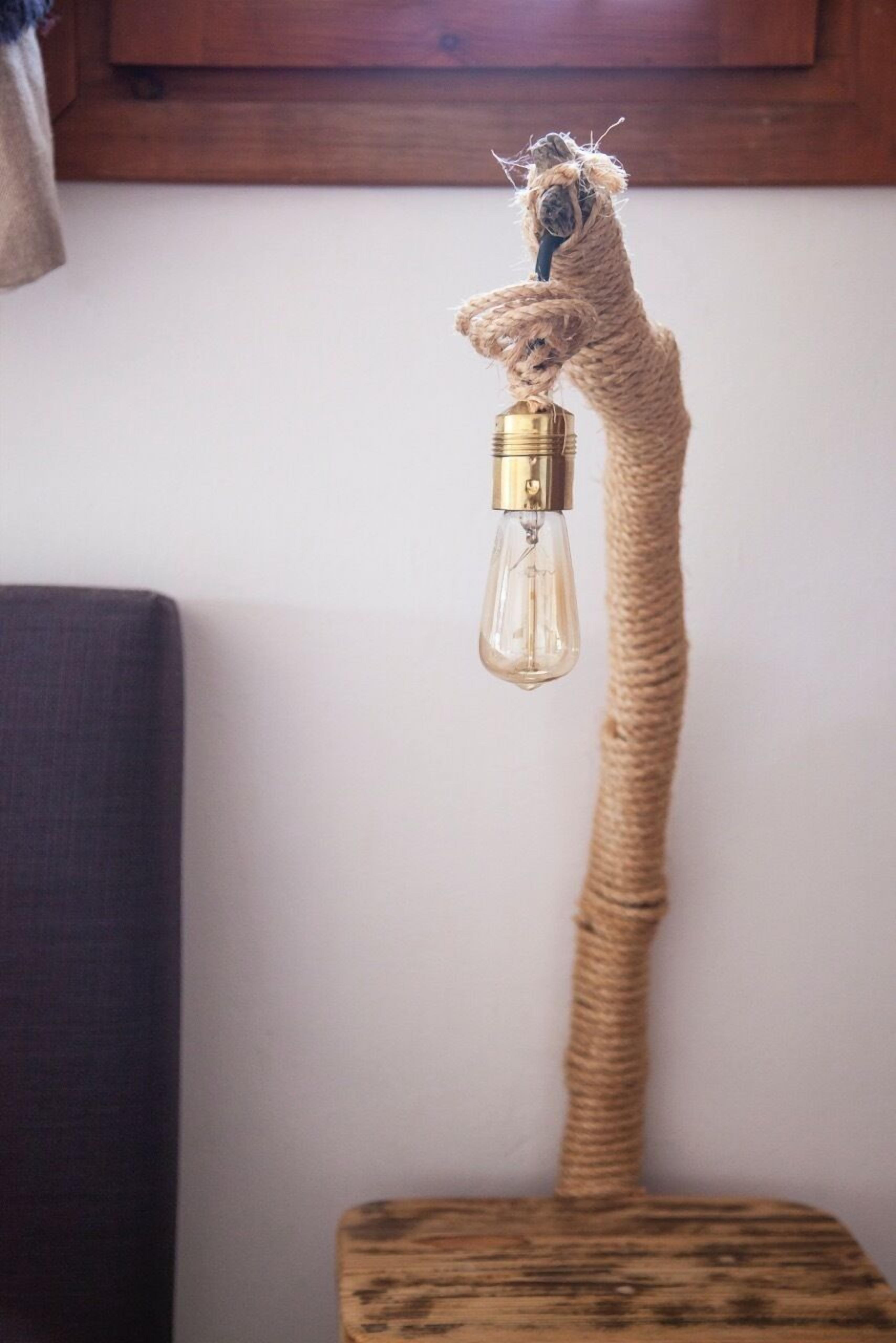 Ett unikt klätterträd för katter med en struktur av rep och en hängande lampa.