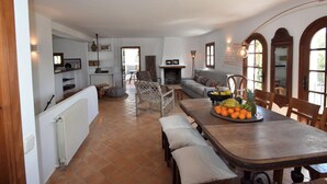 Un saló espai ós amb una llar de foc, una zona de menjador amb un plat de fruita i una cuina amb un radiador.