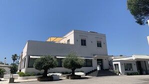 Un edificio moderno de dos pisos con techo plano, ventanas amplias y una escalera que conduce a la entrada.
