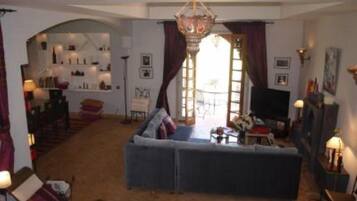 Télévision, cheminée, lecteur de DVD, livres