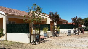 A residential area with houses, a green hedge, and potted plants. - Studio on on a flowered land of 3000 square meters, view on the mountain (Calvi)