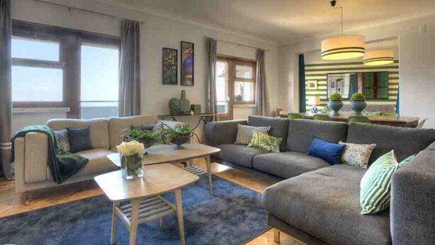 A modern living room with a sofa set, a coffee table, and a dining area. - 30 guests Upper Class (Lisboa)