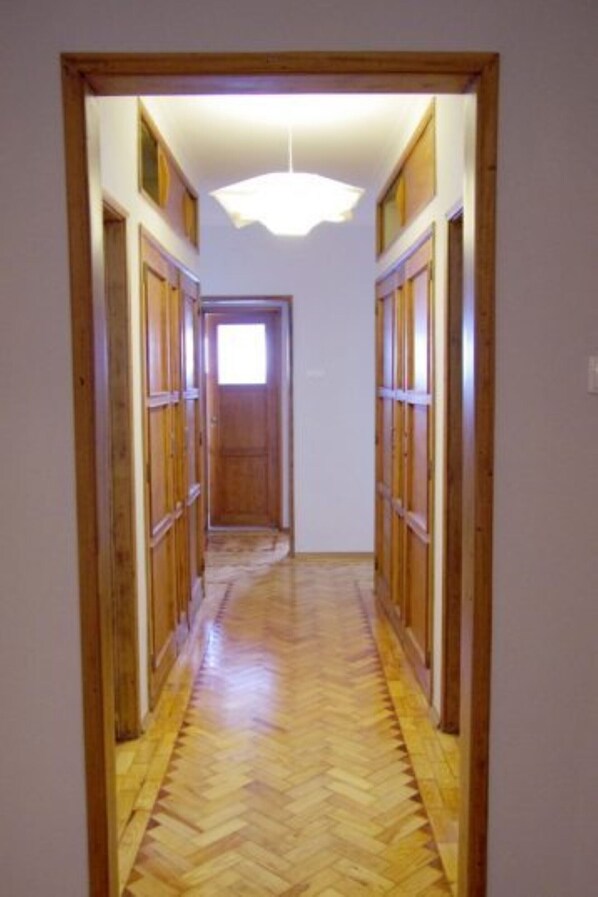 A hallway with wooden paneling and a herringbone floor pattern. - 30 guests Upper Class (Lisboa)
