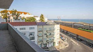 A view from a balcony overlooking a coastal area with buildings, a road, and a bridge. - 30 guests Upper Class (Lisboa)