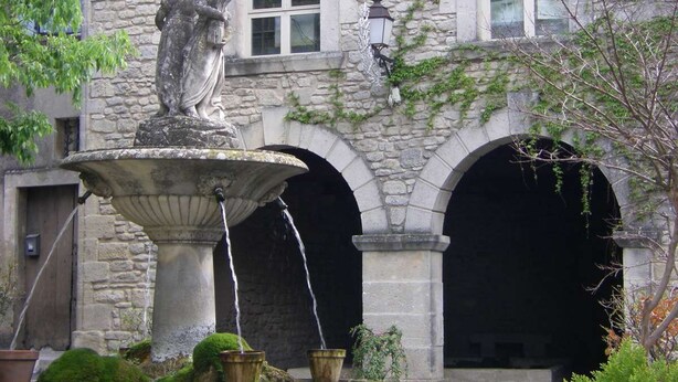 A stone building with a fountain, arched doorways, and a statue. - Three Levels -2 Bedroom-2 Bathroom-alfresco Terrace-fully Renovated (Saignon)