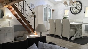 A spacious living area with a staircase, white furniture, and a large wall clock. - Three Levels -2 Bedroom-2 Bathroom-alfresco Terrace-fully Renovated (Saignon)