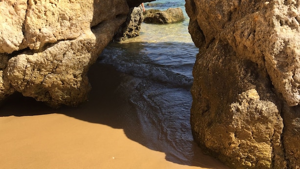 Eine natürliche Felsformation mit freiem Blick auf das Meer durch einen Torbogen.