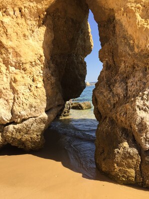 A natural rock formation with a clear view of the sea through an archway. - Sunny and modern apartment near the beach (Lagos, Portugal)