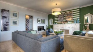 A living room with a sectional sofa, a smaller sofa, a TV, and a fireplace.