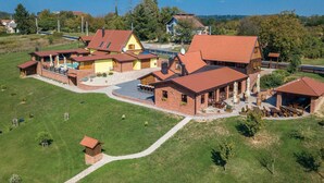 Un grand bâtiment à plusieurs étages, doté d’un toit rouge, entouré d’une pelouse bien entretenue et de quelques arbres.