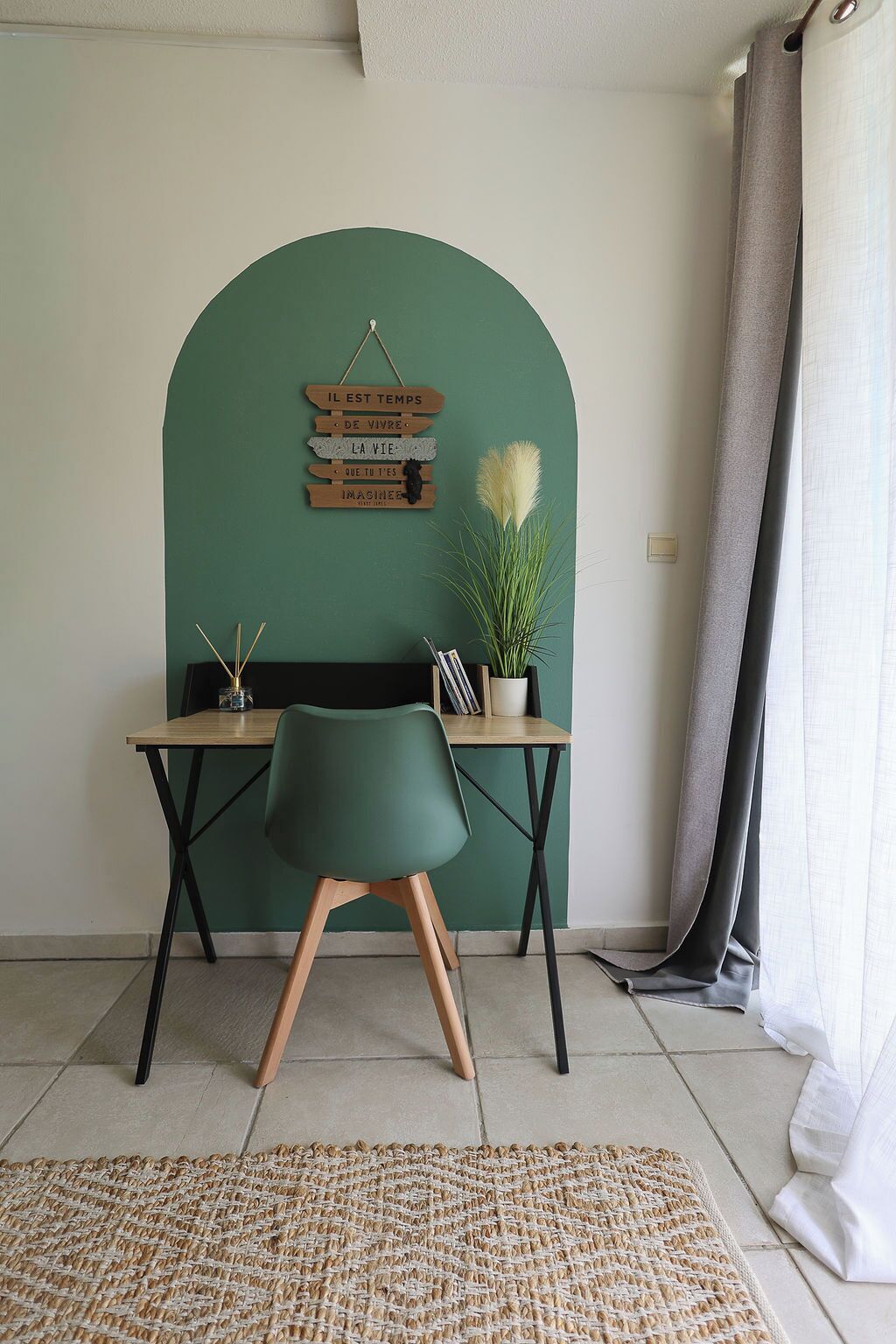 A room with a desk, chair, and a wall-mounted sign with French phrases.