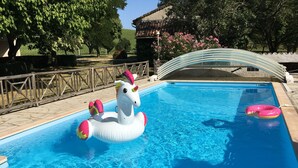Una piscina con un flotador de unicornio y un flotador rosa en forma de aro.