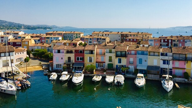 A marina with colorful buildings and boats docked. - Apartment in lake city of Grimaud harbor with beautiful view (Port Grimaud)