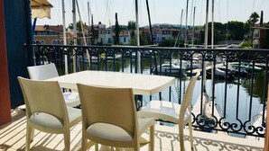 A balcony with a table and chairs overlooking a marina with boats. - Apartment in lake city of Grimaud harbor with beautiful view (Port Grimaud)