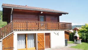 A two-story wooden house with a balcony, a chimney, and a small outdoor grill. - Independent wooden chalet  (Le Tholy)