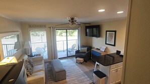A compact living space with a kitchenette, a dining area, and a seating area with a view of the outdoors. - Adorably furnished and updated Ocean Villa condo, with wonderful 200+ Reviews! (Hilton Head Island)