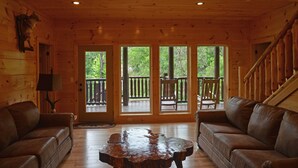 A wooden cabin interior with two leather sofas, a wooden coffee table, and a wooden ceiling with recessed lighting. - Luxury 4 King Suites, 4 Bath Log Cabin Close to Town & Trolley (Gatlinburg)