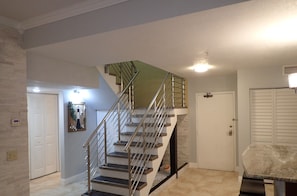 Ein modernes Interieur mit Treppe, einer Tür und einem an der Wand montierten Thermostat.